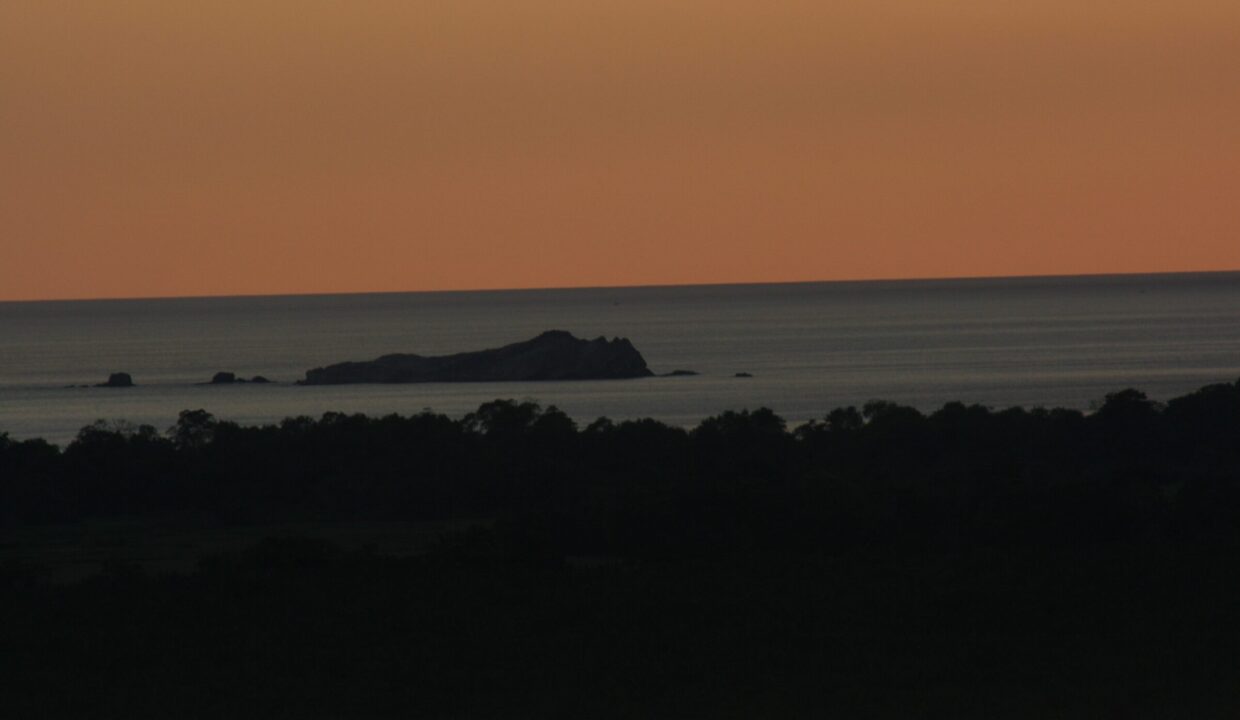 Aerial view of green coastal plains meeting the turquoise Pacific near Playa El Rey, Quepos, Costa Rica