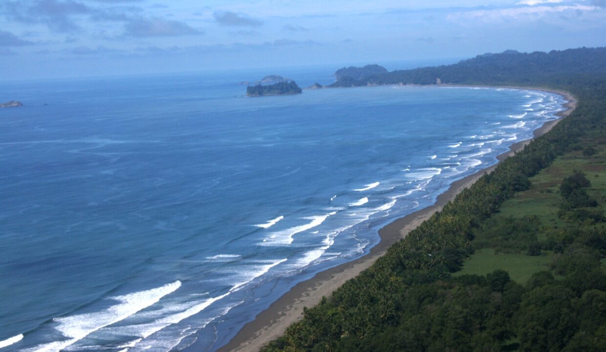 Aerial of a forested cove and turquoise bay near Manuel Antonio, Costa Rica