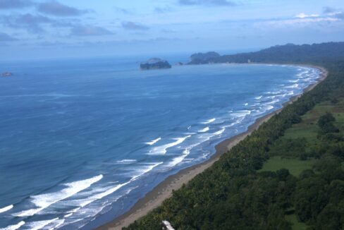 Aerial of a forested cove and turquoise bay near Manuel Antonio, Costa Rica