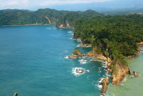 Turquoise Pacific bay and rainforest shoreline near Quepos, Costa Rica